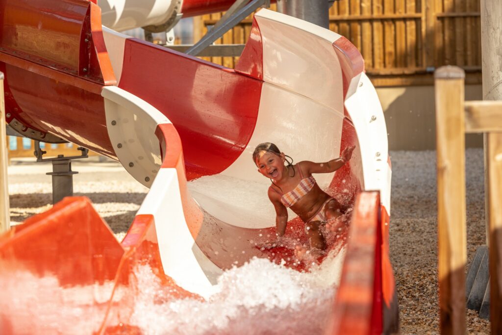 Petite fille jouant dans le toboggan aquatique de la Chapelle